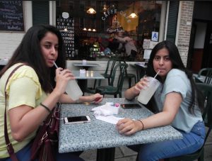 Ally Alzaid (left) and her sister Anna take time out to sip lemonade outside Café Caffe. Eagle photos by Paula Katinas