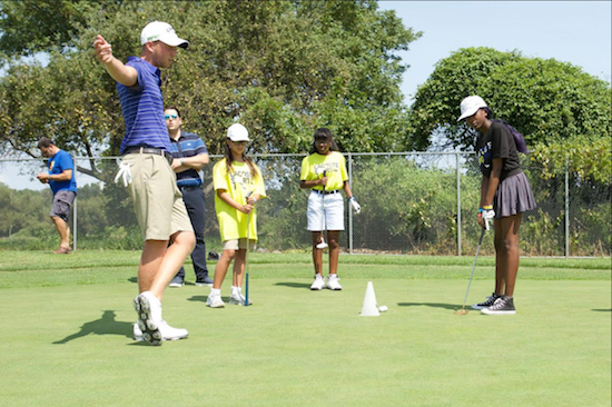 Pro golfer Daniel Berger gives tips to young golfers on the putting green. Photo by Alan Roche