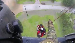 Members of the New York National Guard's 106th Rescue Wing can be seen hanging onto their scared passengers as they are hauled by rope up to a rescue helicopter. Image courtesy of the New York National Guard