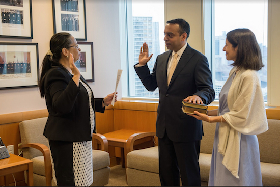 Chief Judge Dora Irizarry (left) swears in Magistrate Judge Sanket Bulsara (center) during an informal ceremony at the courthouse while his wife Christine DeLorenzo looks on. Photo courtesy of the Eastern District of New York