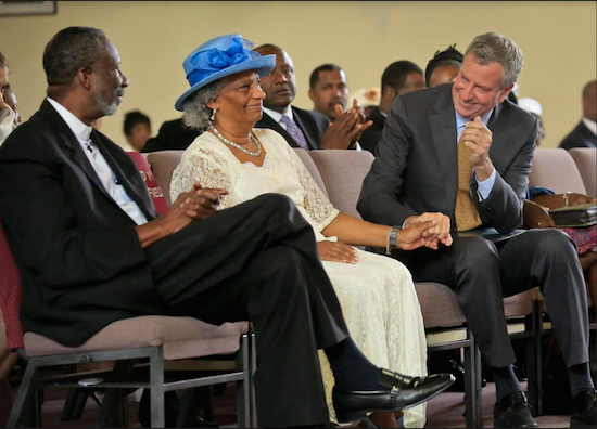 In a Sunday, Sept. 3, 2017 photo, New York City Mayor Bill de Blasio, right, talks with senior pastor Dr. Alfred Cockfield, left, and his wife Linette Cockfield, center, during his visit to their church, God's Battalion of Prayer Church, in East Flatbush. The city's minority population holds the key to de Blasio's re-election test. AP Photos/Bebeto Matthews