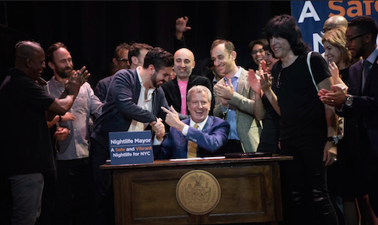 Mayor Bill de Blasio (center) celebrates with Councilmember Rafael Espinal on Tuesday night after the mayor signed into law legislation to create an Office of Nightlife and Nightlife Advisory Board. Courtesy of NYC Mayor’s Office