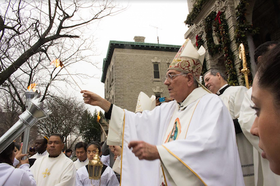 Bishop Nicholas DiMarzio lights the torches of leaders of the procession routes following a December 2015 Mass honoring Our Lady of Guadalupe and celebrating the heritage of Mexican-American immigrants. DiMarzio has been a strong advocate for Brooklyn’s immigrant community and its needs. Eagle file photo by Francesca N. Tate