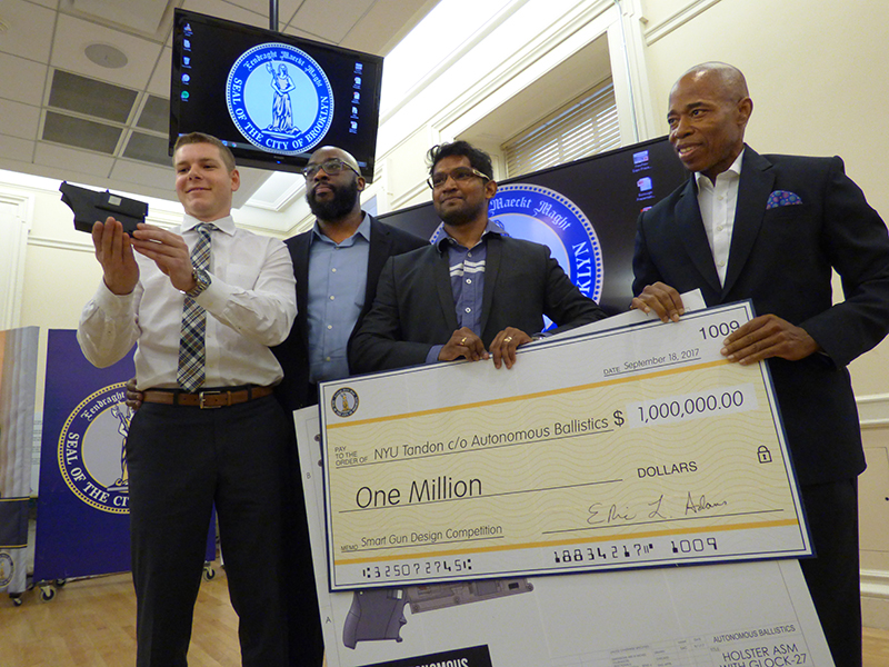 Autonomous Ballistics, a team from New York University Tandon School of Engineering, won the $1 million prize in a Smart Gun Design Competition funded by Borough President Eric Adams. Shown from left: Sy Cohen, mentor Professor Anthony Clarke, Ashwin Raj Kumar and Borough President Eric Adams. Photo by Mary Frost