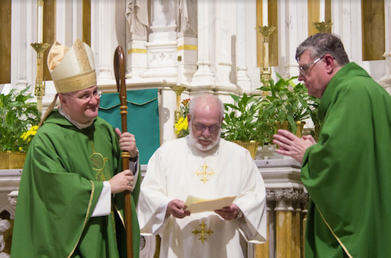 Bishop James Massa, at left, smiles as Deacon Edward Gaine (center, wearing white dalmatic) reads the official document of installation to the Rev. William G. Smith. Eagle photo by Francesca N. Tate