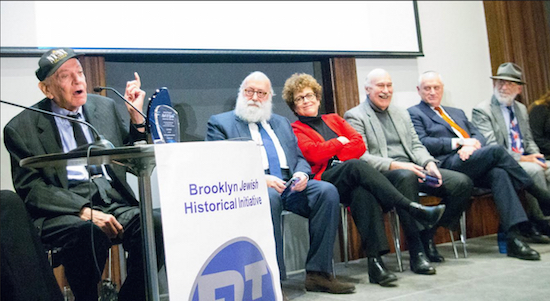 Eli Miller’s fellow honorees enjoy his story of his adventures getting into the seltzer business. Left to right: Miller, Rabbi Simon Jacobson, Judith Clurman, Ira Glasser, Martin Hoenlein and David Dubrow. Not pictured: Merle Feld, Norman Siegel and Assemblymember Helene Weinstein. Eagle photo by Francesca N. Tate