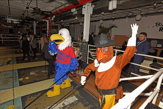 Left, Brooklyn Eagle mascot “Eddie the Eagle” battles the Turkey Classic mascot at Royal Palms. Eagle photos by Andy Katz