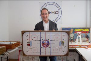 John Fayolle displays one of his table hockey boards with an Islanders decal at center ice. Eagle photo by Cody Brooks