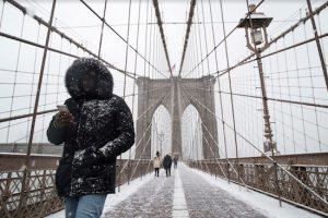 Pedestrians walk across the Brooklyn Bridge walkway in the snow last January. While there were few walkers and no bicyclists when this photo was taken, one can see how narrow the path is. AP file photo by Mary Altaffer