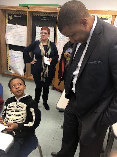 Dr. Marcus Bright, executive director of the organization Better Education for America, chats with a student at the curriculum celebration. Photo courtesy of New American Academy Charter School