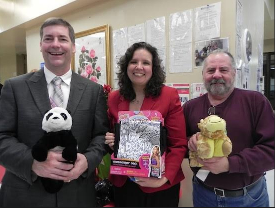 Greg Ahl (right) has been organizing a Christmas toy drive for the Center Against Domestic Violence for more than two decades, working with Community Board 10 colleagues like former chairman Brian Kieran and District Manager Josephine Beckmann to collect toys. Eagle file photo by Paula Katinas