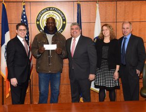 Brooklyn District Attorney-elect Eric Gonzalez and Department of Investigation Commissioner Mark Peters present $750,000 in restitution checks to five electricians of a former Red Hook construction company. From left: Commissioner Mark Peters, worker Adrian Hayes, DA-elect Eric Gonzalez, ADA Samantha Magnani and investigator Nick Scicutella. Photos courtesy of the Brooklyn DA’s Office