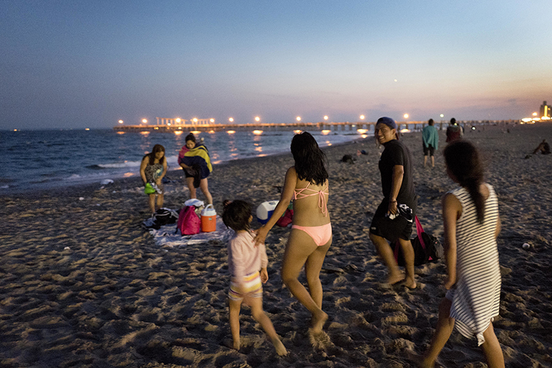 A family heads to the beach for a quiet evening swim at Coney Island.  AP Photo/Mark Lennihan