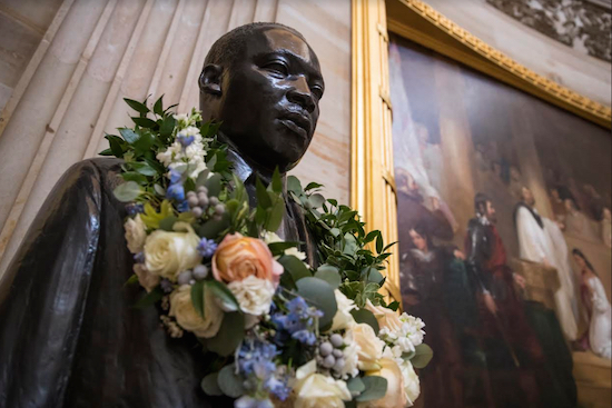 In this Thursday photo, the bust of civil rights activist and leader Martin Luther King Jr. is draped with a wreath of flowers to commemorate his birthday in the Capitol Rotunda in Washington. AP Photo/J. Scott Applewhite