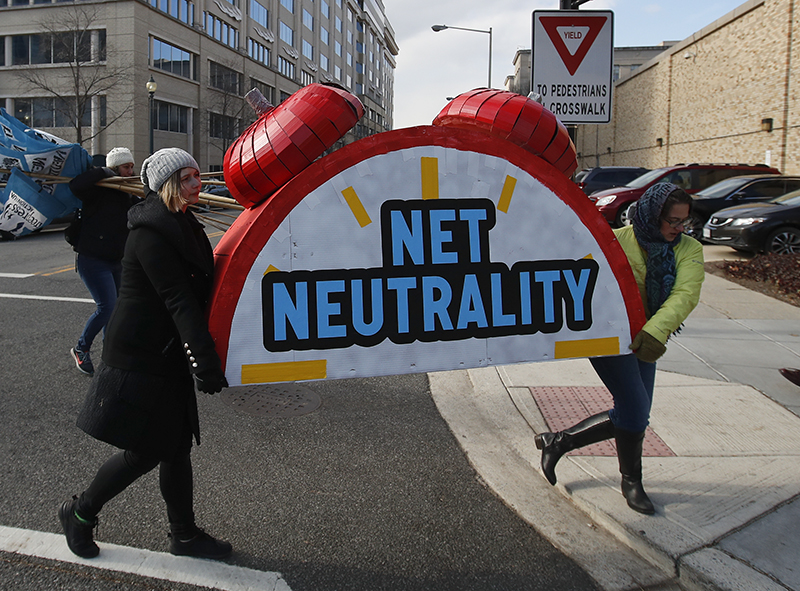 Supporters of net neutrality carried the top of an alarm clock in Washington, D.C., after a protest at the Federal Communications Commission (FCC) in December, where FCC voted to dismantle net neutrality. Now Gov. Andrew Cuomo is defying FCC. AP photo by Carolyn Kaster