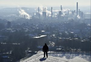 In this Jan. 19, 2016 file photo, a man watches a BP refinery in Gelsenkirchen, Germany. New York City officials say they will begin the process of dumping about $5 billion in pension fund investments in fossil fuel companies, including BP, because of environmental concerns. AP Photo/Martin Meissner, File