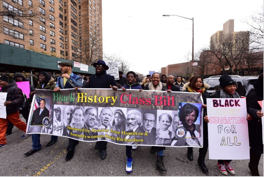 From left: Mike Tucker, Akeem Browder, Kevin McCall, Malcolm Xavier Combs and Mercedes Liriano-Clark march with their banner around Medgar Evers College.