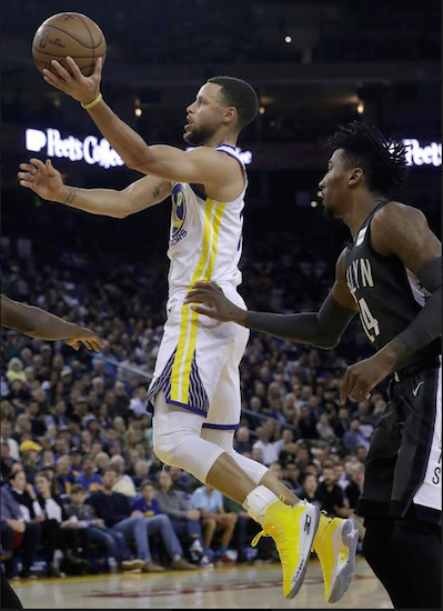 Stephen Curry rises for two of his game-high 34 points Tuesday night as the NBA champion Golden State Warriors used a big second half to cruise past the slumping Brooklyn Nets in Oakland. AP Photo by Jeff Chiu