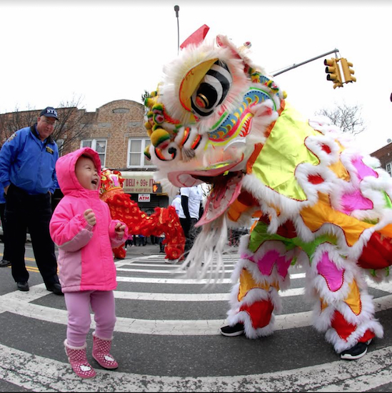 A young child is happy to meet the dancing lion at the parade on 18th Avenue. Eagle photos by Arthur De Gaeta