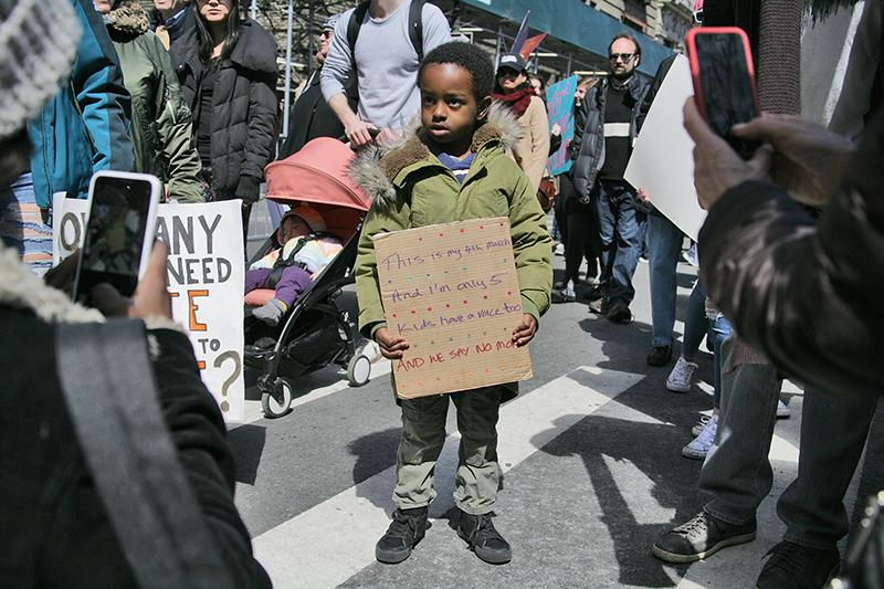 A child holds a sign reading, "This is my fourth march and I'm only 5. Kids have a voice too. And we say no more," at Saturday’s March For Our Lives gun control rally in Manhattan. Photo courtesy of Michael Campina