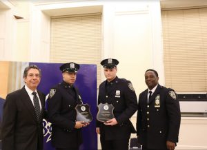 Officers Steven Nieves (second from left) and Mike Skelton (second from right) beam proudly with family after receiving the Officer of the Month Award. They are pictured with 84th Precinct Community Council President Mark Gelbs (left) and Executive Officer Tyrice Miller. Eagle photo by Edward King