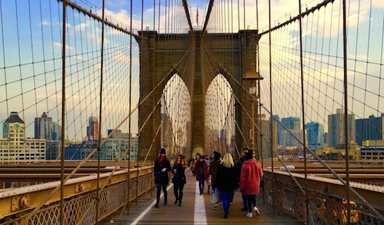Visitors stroll along the Brooklyn Bridge's bike and pedestrian lanes. Eagle file photo by Lore Croghan