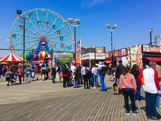 Ticket buyers stand on the Coney Island Boardwalk outside the Wonder Wheel.