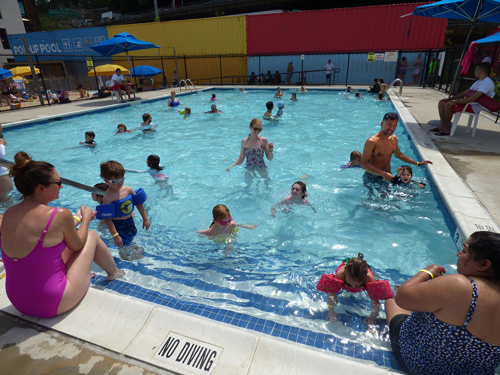 Local officials say Brooklyn Bridge Park needs to start working on a plan for a pool there during the summer of 2019. Shown: Dozens of families cooled off in the Pop-Up Pool on opening day last June. Photos by Mary Frost