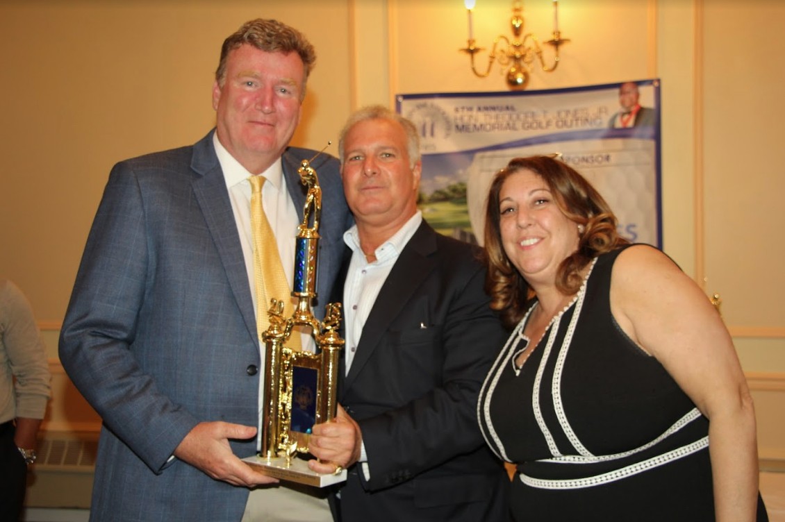 Gregory Cerchione (center) and Aimee Richter present Hon. Bernard Graham with an award for being closest to the pin on the 6th hole.