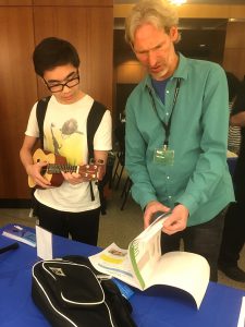Brooklyn Public Library patrons check out musical instruments, like the ukulele seen here, which are available for borrowing at the Central Library. The new lending program, which launched on Wednesday, is wildly popular.  Photo courtesy of Beverly Closs