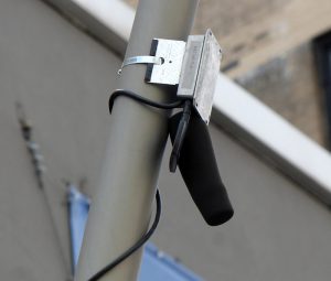 NYU’s startup Sounds of New York City is developing an acoustic sensor network and installing it on lampposts along Fulton Street. Show above is one of the nearly foot-long microphones which will be picking up sounds on Fulton Street. Photo by Mary Frost