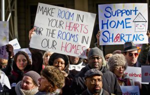 Supporters of Airbnb hold a rally outside City Hall. Airbnb hosts say that income from renters helps them afford housing costs. AP file photo by Bebeto Matthews