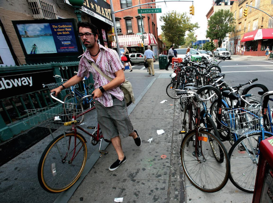 In this file photo, Williamsburg resident John Shannon searches for a space for his bicycle at a bike rack on Bedford Avenue. Will we someday see similar scenes near Atlantic Avenue? AP Photo by Bebeto Williams