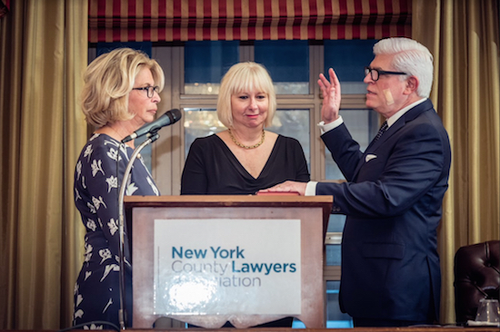 Michael Miller, the 121st president of the New York State Bar Association, is sworn in by NYS Chief Judge Janet DiFiore, as his wife Cindy looks on. Photo courtesy of the NYS Bar Association