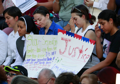 People gather at Saint Mark Catholic Church for a solidarity with migrants vigil on June 21, 2018 in El Paso, Texas. President Donald Trump's order ending the policy of separating immigrant families at the border leaves a host of unanswered questions, including what happens to the more than 2,300 children already taken from their parents and where the government will house all the newly detained migrants in a system already bursting at the seams. AP Photo/Matt York