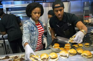 For a neighborhood celebration, BCCC students Chloe Hadley, left, and Travis Maxwell cooked jerk chicken and sliders. Photos by Andrew Lichtenstein