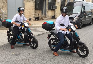 Revel Transit founders demonstrated how easy it is to rent and ride a moped at a press conference in Bushwick on Monday. The city’s first-ever shared electric moped service works like Citi Bike. Eagle photo by Mary Frost