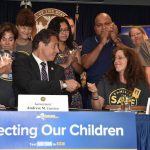 Gov. Andrew Cuomo gives the pen he used to sign the speed camera executive order to Families for Safe Streets Founder Amy Cohen. Photo from GovAndrewCuomoFlickr