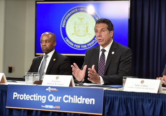Gov. Andrew Cuomo (right) signed an emergency declaration that paved the way for Mayuor Bill de Blasio and the City Council to take action re-activate speed cameras in school zones. At left is Alphonso David, the governor’s counsel. Photo from GovAndrewCuomoFlickr