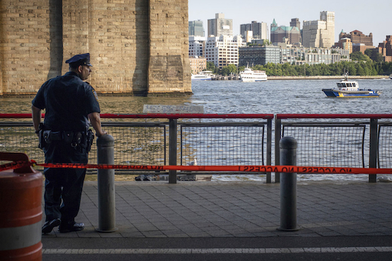 A New York Police Department officer stands guard as authorities investigate the death of a baby boy who was found floating in the water near the Brooklyn Bridge in Manhattan, on Sunday. No parent or guardian was present at the scene and the child showed no signs of trauma, police said. The medical examiner will determine the exact cause of death. AP Photo/Robert Bumsted