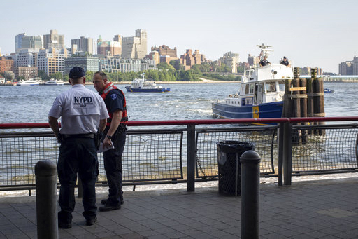 In this Aug. 5, 2018, file photo, authorities investigate the death of a baby boy who was found floating in the East River near the Brooklyn Bridge in Manhattan in New York. A Bronx father hopped a plane to Thailand after carrying his dead 7-month-old baby around New York City in a backpack and tossing the boy's body into the river and other tourist hotspots, police said Wednesday. AP Photo/Robert Bumsted, File