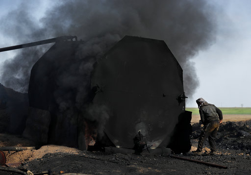 In this April 6 photo, a former farmer works at a primitive refinery as he makes crude oil into diesel and other products, in Rmeilan, Hassakeh province, Syria.  AP Photo/Hussein Malla, File