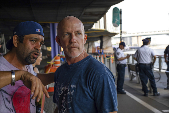 Monte Campbell, of Stillwater, Okla., right, stands under the Brooklyn Bridge in Manhattan after jumping into New York’s East River to rescue a baby floating in the water, on Sunday. The baby was later pronounced dead and authorities are investigating. No parent or guardian was present at the scene and the child showed no signs of trauma, police said. AP Photo/Robert Bumsted