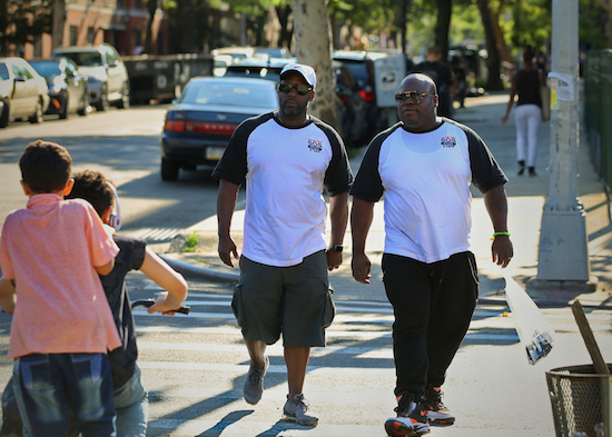 In this July 20 photo, Joshua Simon, left, and Lawrence Brown, right, outreach workers with Save Our Streets, an organization that employs former gang-members and residents to stop fights from escalating to violence, canvas Bedford-Stuyvesant. Both serve as mentors teaching young men and women on how to resolve disputes without bloodshed. AP Photos/Stephen Groves