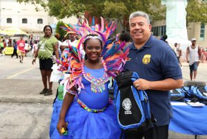 Brooklyn District Attorney Eric Gonzalez (right) stands with an attendee from the Junior Carnival Parade on Saturday. Photo courtesy of the Brooklyn DA’s Office