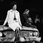 Rep. Shirley Chisholm sits on a battered automobile, a prop in the play "Ain't Supposed to Die A Natural Death," as she addresses a theater audience in New York City on 1972. AP file photo