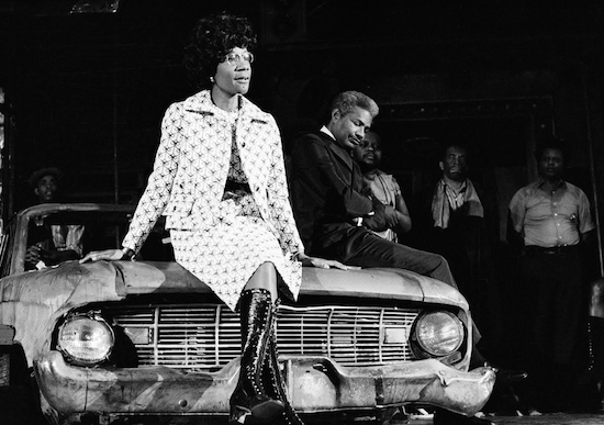 Rep. Shirley Chisholm sits on a battered automobile, a prop in the play "Ain't Supposed to Die A Natural Death," as she addresses a theater audience in New York City on 1972. AP file photo