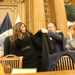 Hon. Gina Levy Abadi’s husband Joseph helps her during the official robing ceremony.