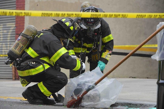 Firefighters had to remove this bucket containing an unknown green substance which officials say may have fallen from a truck on Atlantic Avenue.. Eagle photos by Todd Maisel