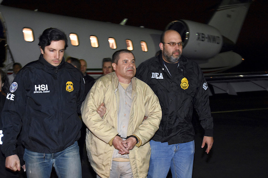 FILE - In this Jan. 19, 2017 file photo provided by U.S. law enforcement, authorities escort Joaquin "El Chapo" Guzman, center, from a plane to a waiting caravan of SUVs at Long Island MacArthur Airport, in Ronkonkoma, N.Y. Guzman's trial is set to begin Monday, Nov. 5, 2018, with jury selection. Opening statements are expected on Nov. 13. U.S. law enforcement via AP, File